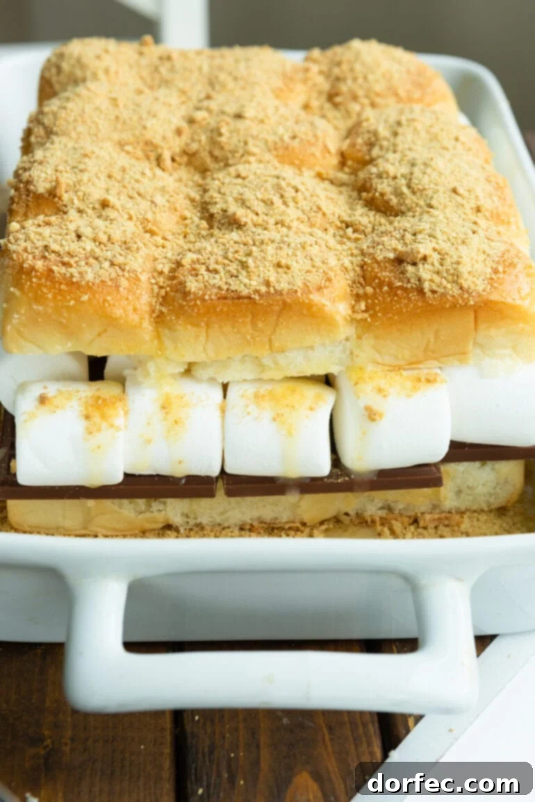 S'mores Sliders 6 S'mores slider buns, generously loaded with chocolate and large marshmallows, topped with a hearty sprinkle of graham cracker crumbs, perfectly prepped and ready for baking.