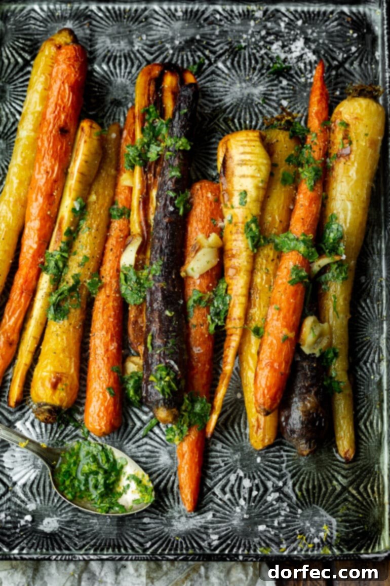 a photo of multi colored carrots and parsnips that have been roasted and drizzled in a lemon honey dressing.
