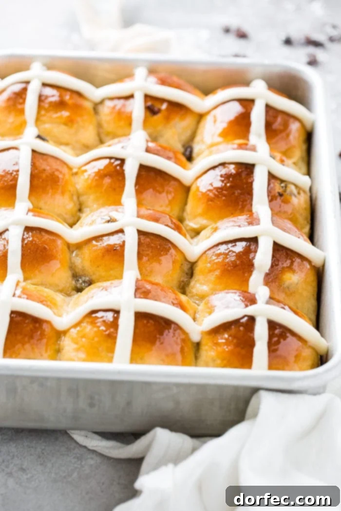 A photo of a silver cake pan of hot cross buns.