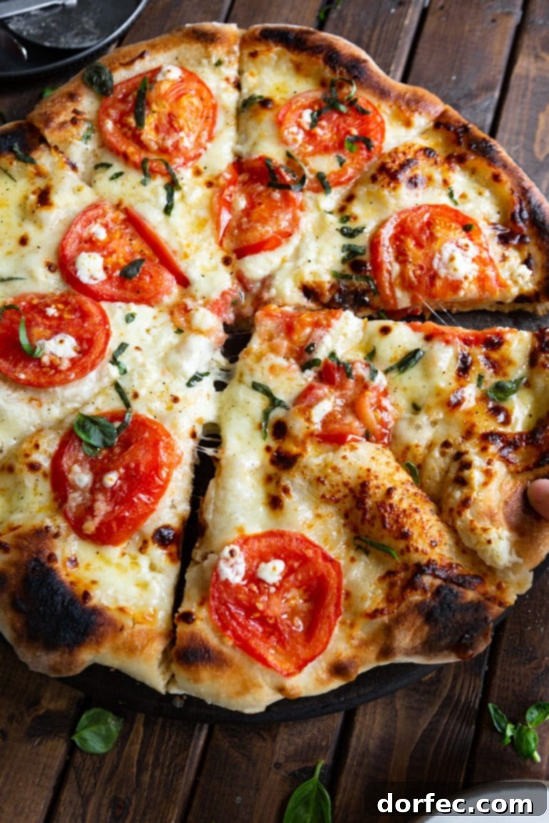 A freshly baked four cheese margherita pizza, expertly sliced with two pieces slightly pulled away, showcasing its delicious crust and melted cheese.