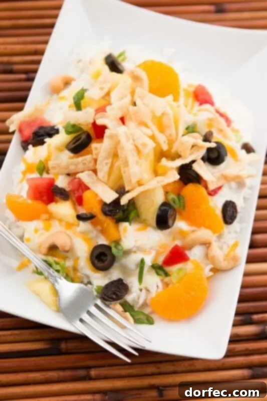 The Ultimate Hawaiian Haystacks served family-style with a creamy chicken base and an array of colorful, customizable toppings like pineapple, shredded cheese, and crunchy noodles.