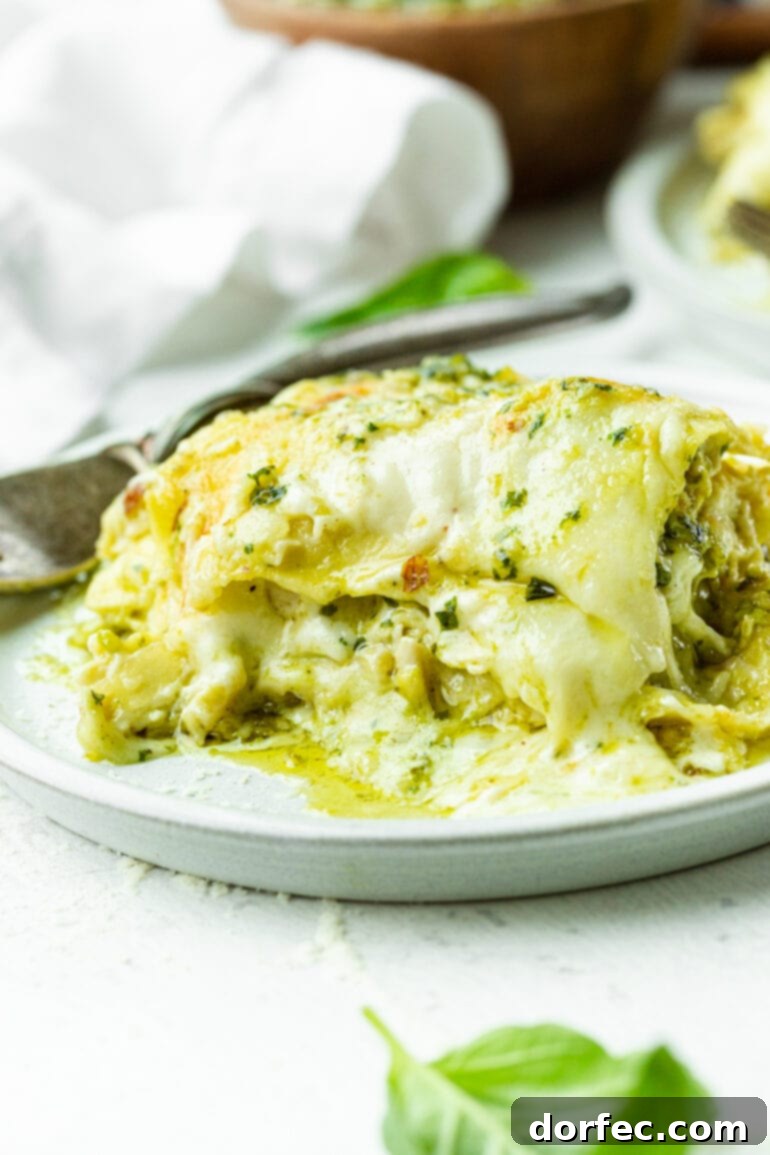 Weekly Meal Plan: April 22-28 6 A generous serving of creamy, cheesy white chicken pesto lasagna, showcasing distinct layers of pasta, chicken, rich sauce, and melted cheese, garnished with fresh herbs.
