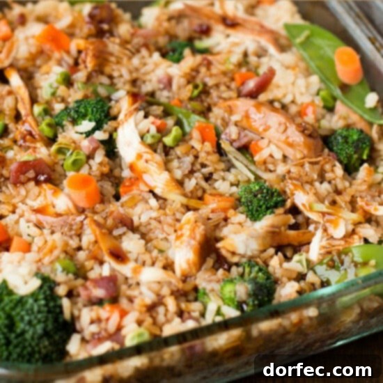A tempting teriyaki chicken casserole, brimming with flavorful fried rice, tender chicken pieces, and vibrant mixed vegetables, creating a perfect weeknight dinner.