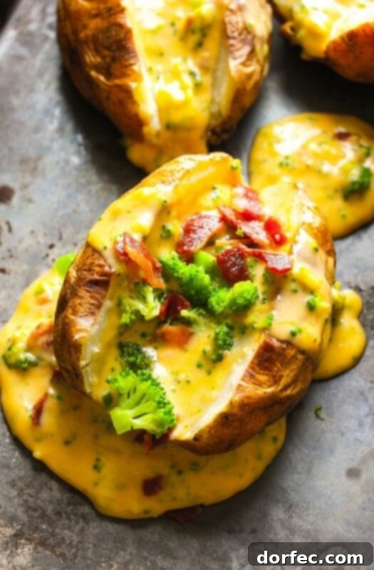 A magnificently loaded baked potato overflowing with creamy homemade cheese sauce, crispy bacon pieces, and fresh green broccoli florets.