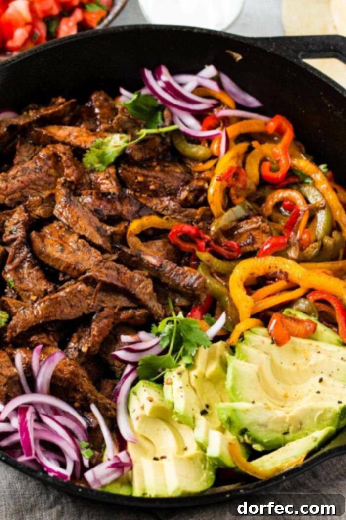 Sizzling, perfectly marinated steak fajitas with an abundance of colorful bell peppers and onions, beautifully arranged and ready to be served for a festive and delicious meal.