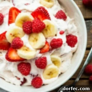 Dreamy Fluffy Cheesecake Fruit Salad 10 A delicious bowl of fluffy cheesecake fruit salad with berries and bananas.