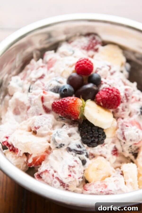 This cheesecake fruit salad is awesome for a side at a potluck or BBQ or even as a dessert! Plus it's so easy it's foolproof! A delectable bowl of cheesecake fruit salad, perfect as a side for a potluck, BBQ, or as a dessert. Its foolproof ease makes it a must-try summer recipe.