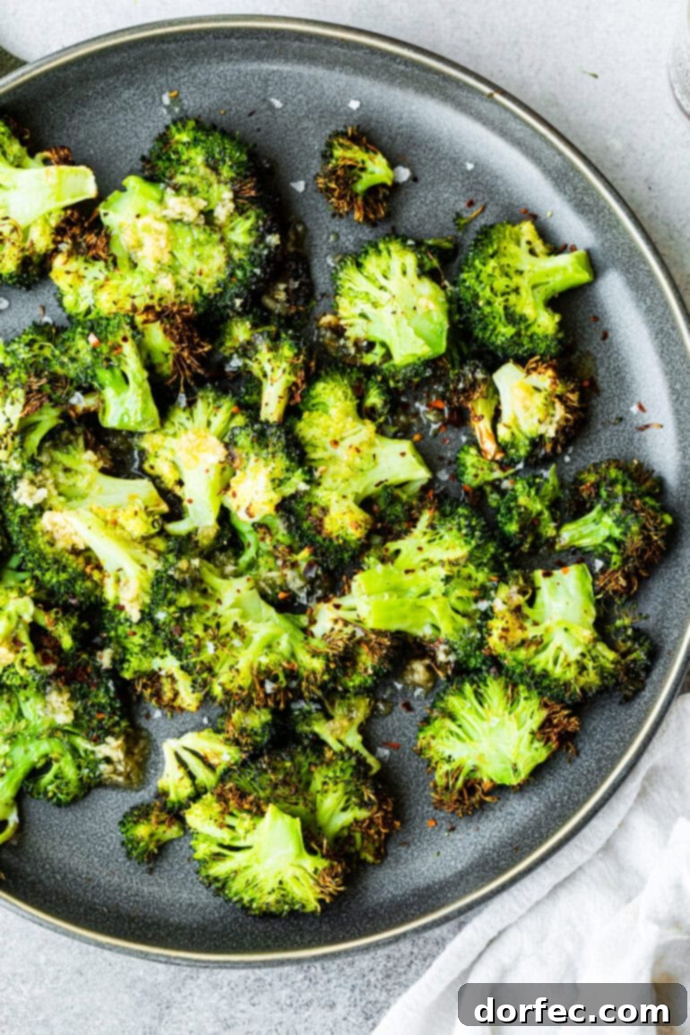 A top-down view of a serving plate filled with an abundance of crispy smashed broccoli florets.