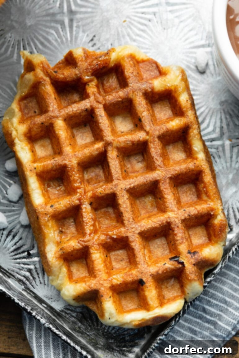A photo taken over the top of a golden cooked rectangular Liege waffle without any toppings on it yet. A beautiful base for delicious additions.