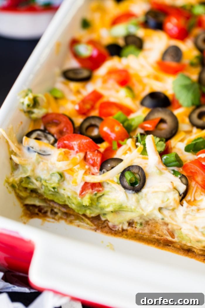 The best Mexican 7 Layer Dip, an ultimate crowd-pleaser, perfect for football game day or any festive gathering.