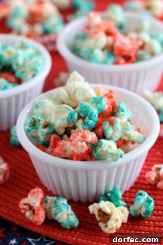 A festive bowl of Patriotic Popcorn, coated in a sweet glaze and sprinkled with red, white, and blue, perfect for Olympic viewing parties.