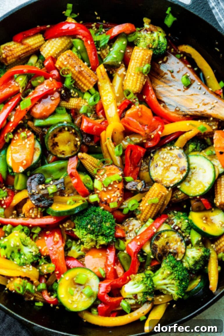 Fast and Fresh Veggie Stir-Fry 3 A close-up view of fresh stir-fry vegetables including zucchini, broccoli florets, vibrant bell peppers, crunchy mini corn, and sliced carrots, ready for cooking.