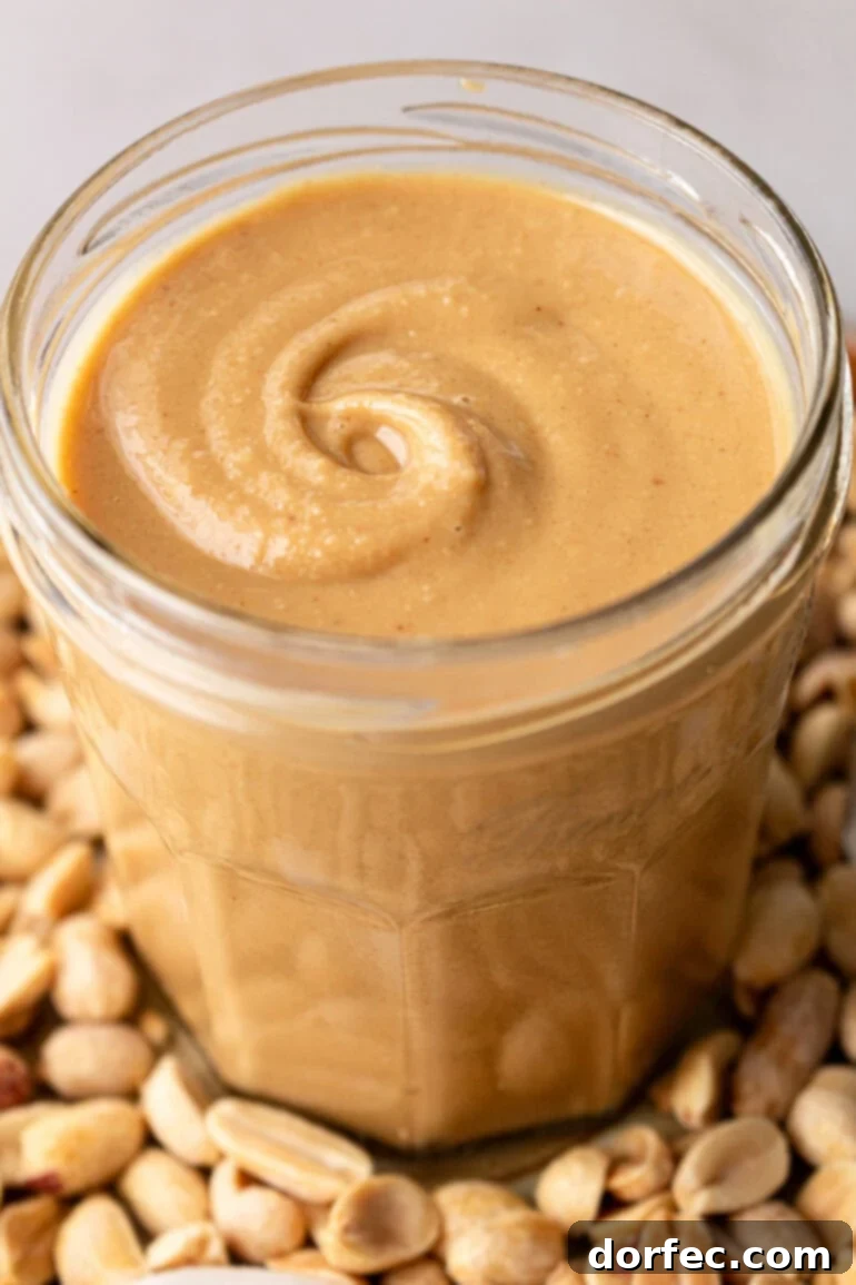 A glass jar filled with creamy homemade coconut peanut butter, showcasing its rich texture and tropical appeal.