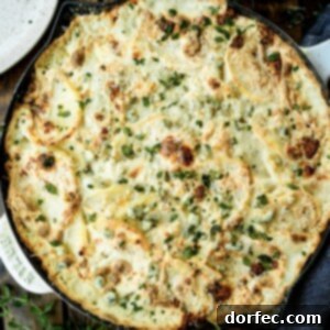 A large skillet full of creamy cheesy potatoes with a container of blue cheese sitting next to it