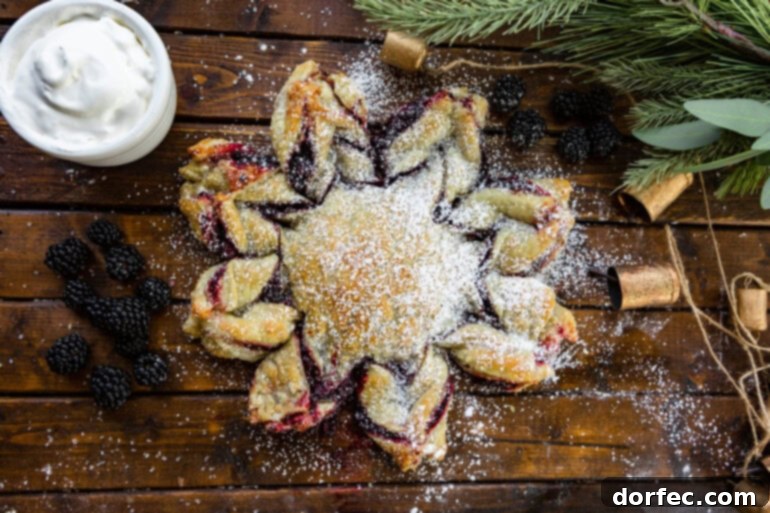 A freshly baked Blackberry Puff Pastry Snowflake, powdered sugar dusted, resting on a rustic wooden table, ready for a holiday gathering.