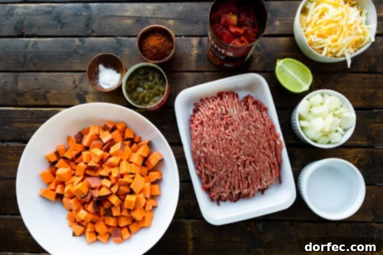 A flat lay photo showcasing all the fresh and pantry ingredients neatly arranged for making a taco ground beef and sweet potato skillet meal.