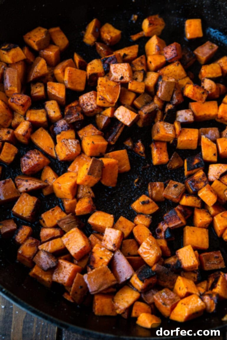 A close-up photo of perfectly sauteed cubed sweet potatoes, lightly browned and tender, ready to be combined with the seasoned ground beef.