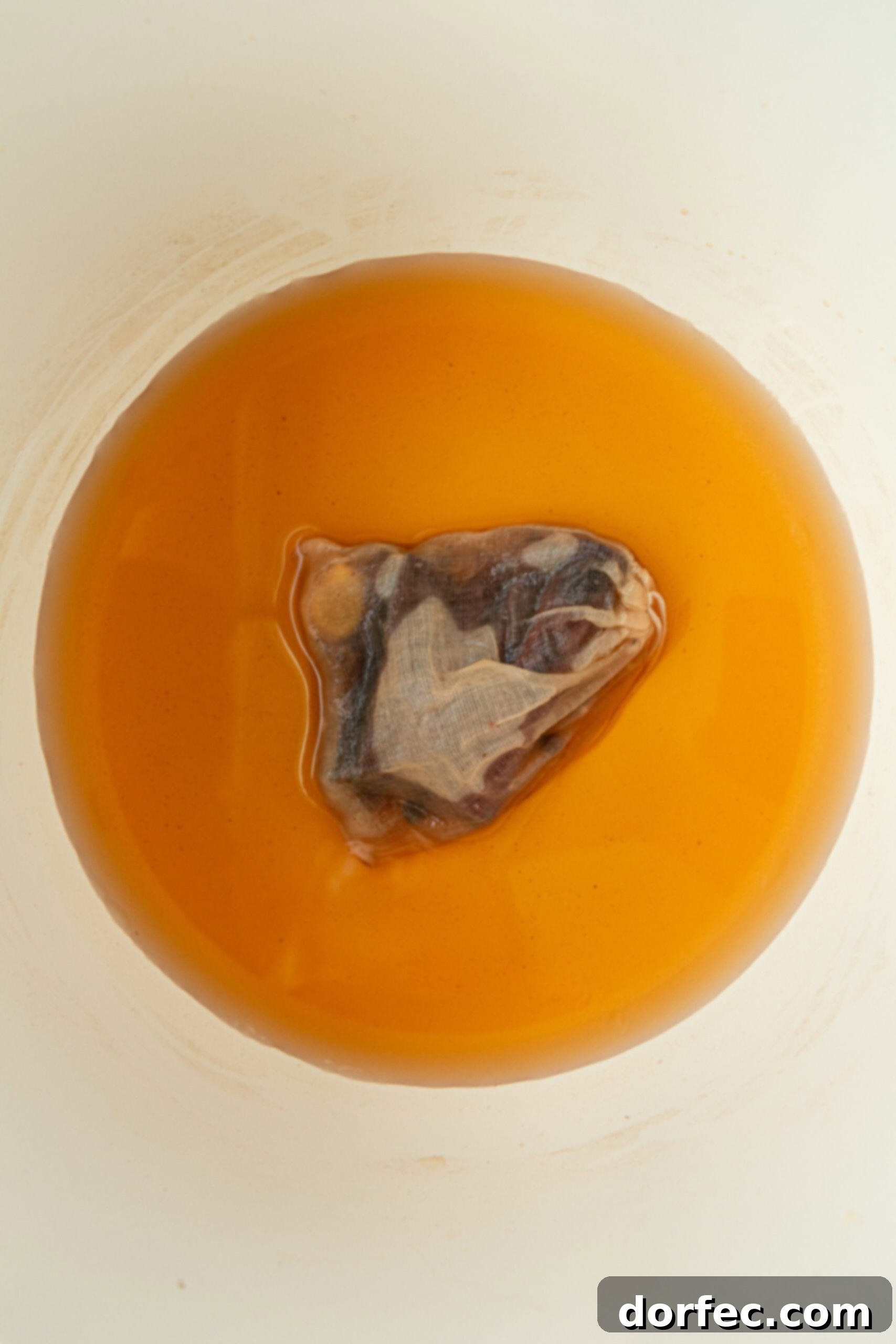 A photo illustrating the final steps for making homemade Wassail, including the addition of fruit juices to the spice-infused base. This warm and flavorful drink is perfect for cozying up by the fire or serving at holiday gatherings.