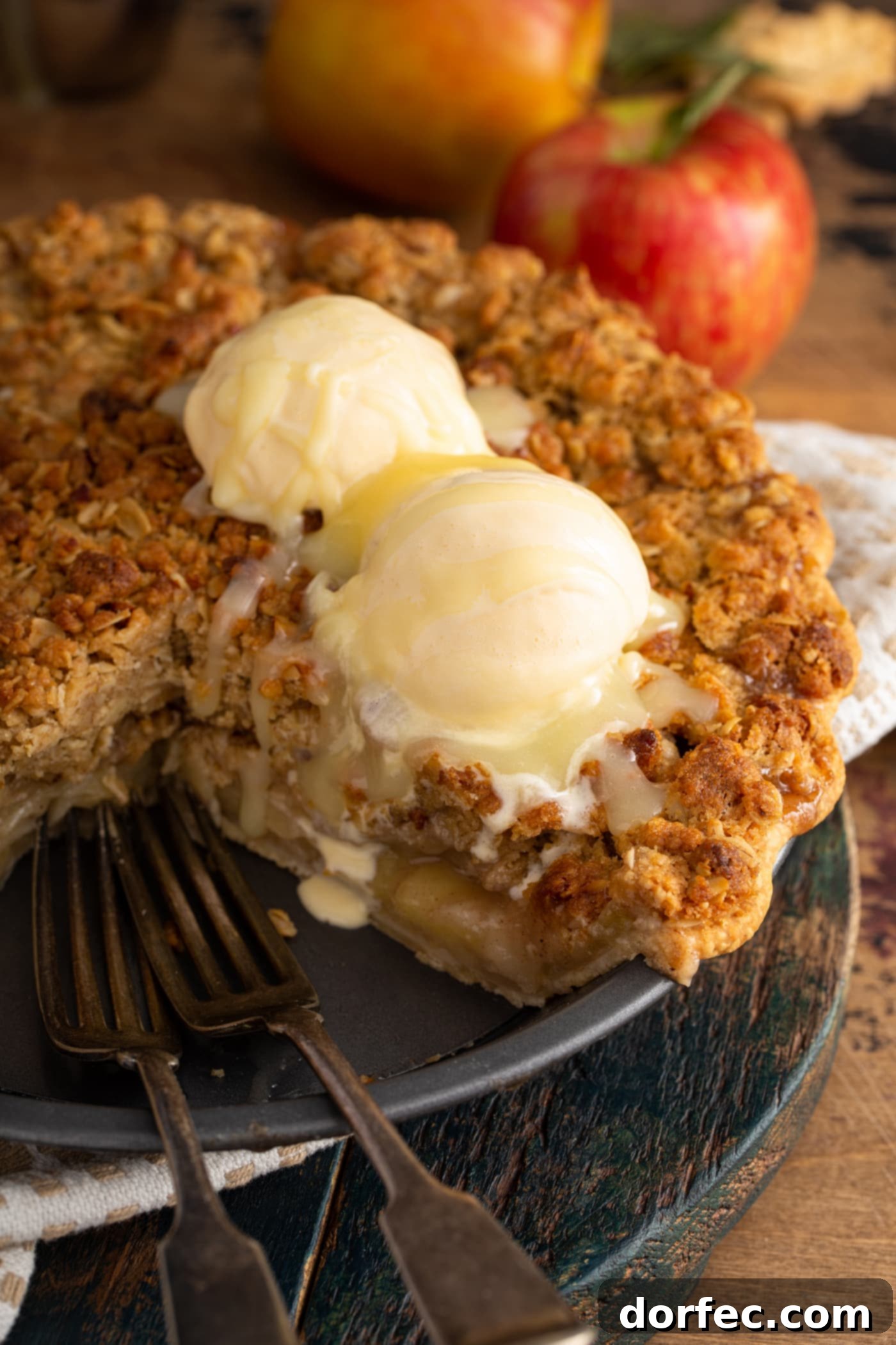 A grand Dutch apple pie with a slice removed, revealing two generous scoops of ice cream melting into the warm apple filling, all sumptuously drizzled with a rich white chocolate butter sauce.