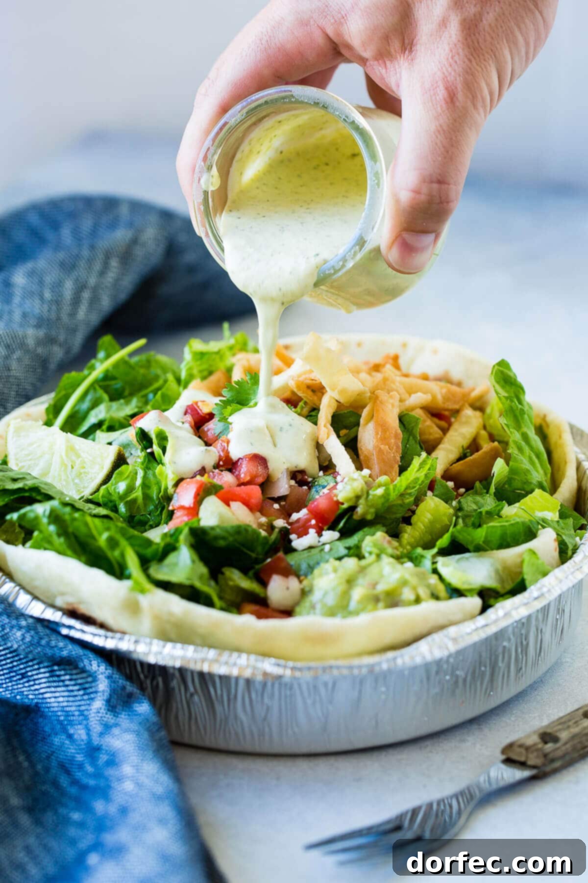 Cafe Rio Shredded Chicken: An Authentic Taste of the Southwest 4 Pouring cilantro ranch dressing over Cafe Rio chicken salad