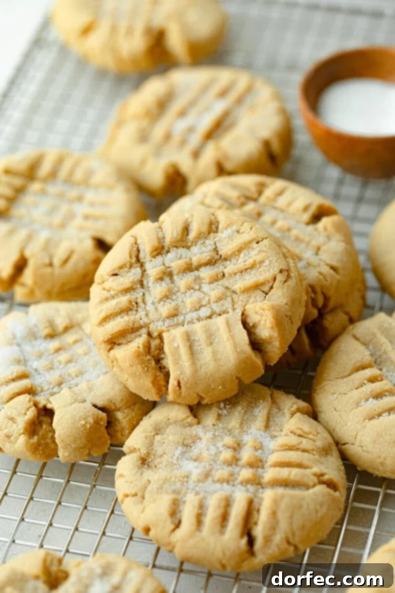 Several baked peanut butter cookies on a cooling rack
