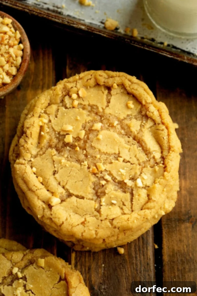 Bakery-Style Peanut Butter Dream Cookies 6 Overhead view of a large, chewy peanut butter cookie on a wooden table.