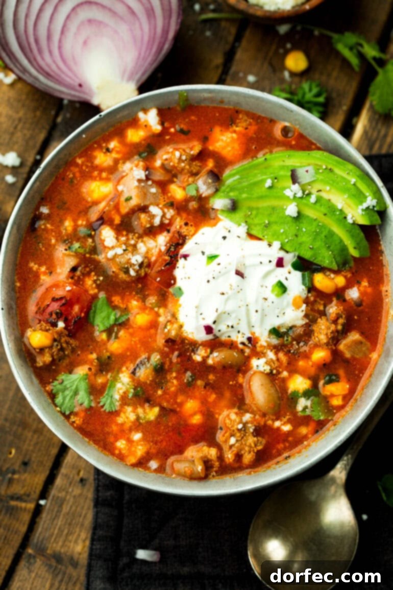 A large bowl of charro bean soup with various toppings