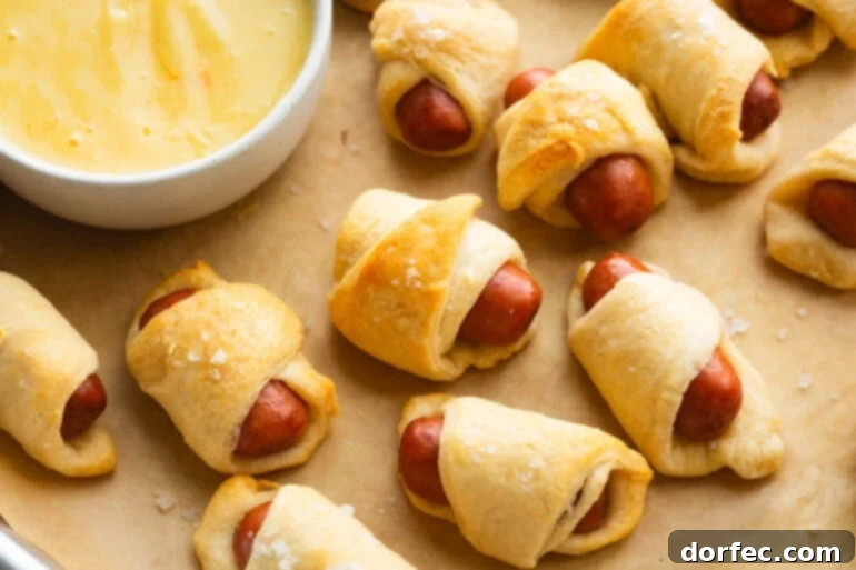 Golden baked pigs in a blanket with homemade dipping sauce