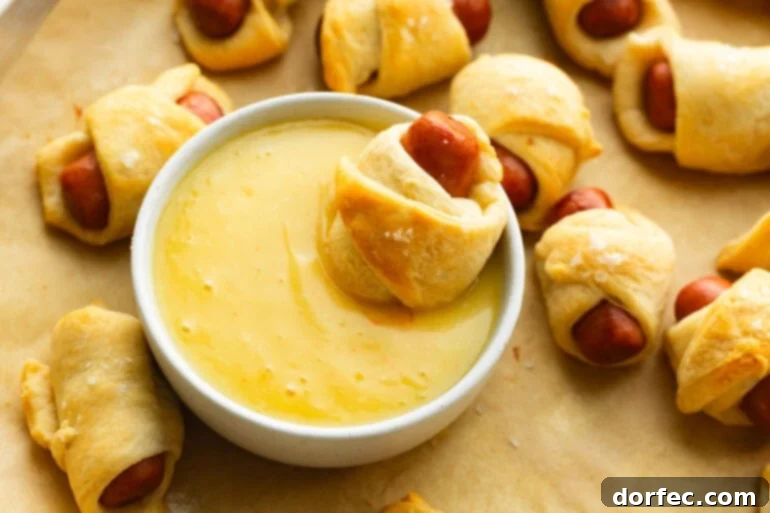 Pigs in a blanket with honey mustard dipping sauce close up