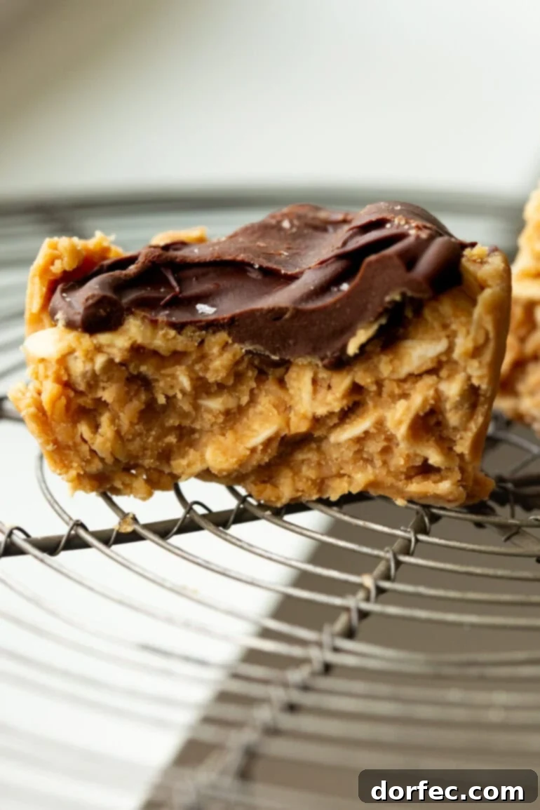 Chocolate Peanut Butter Oatmeal Cups 4 A cross-section of a peanut butter oat cup topped with chocolate on a wire rack