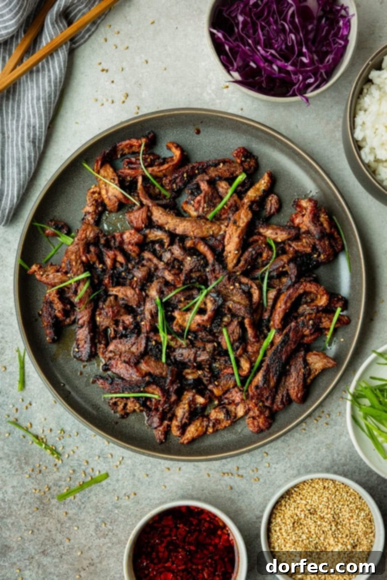 Platter of Korean Bulgogi Beef with sauce, sesame seeds, and green onions
