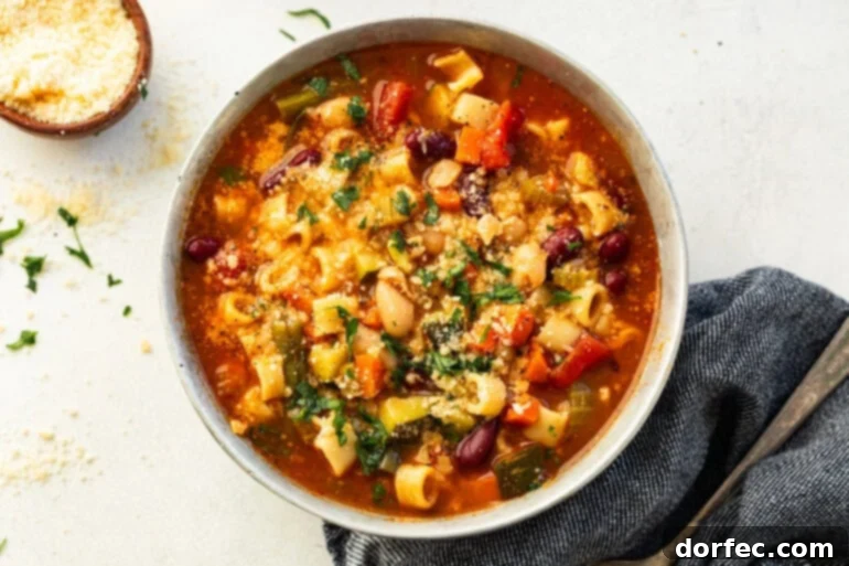 Grandma's Secret-Recipe Minestrone 2 White ceramic bowl filled with classic Minestrone soup, featuring a colorful blend of vegetables in a rich tomato broth.