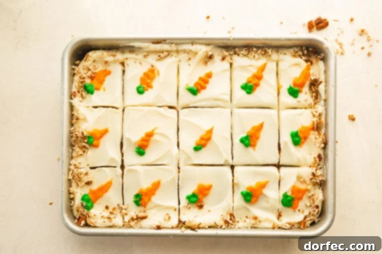 A sliced carrot cake with cream cheese frosting and piped carrots