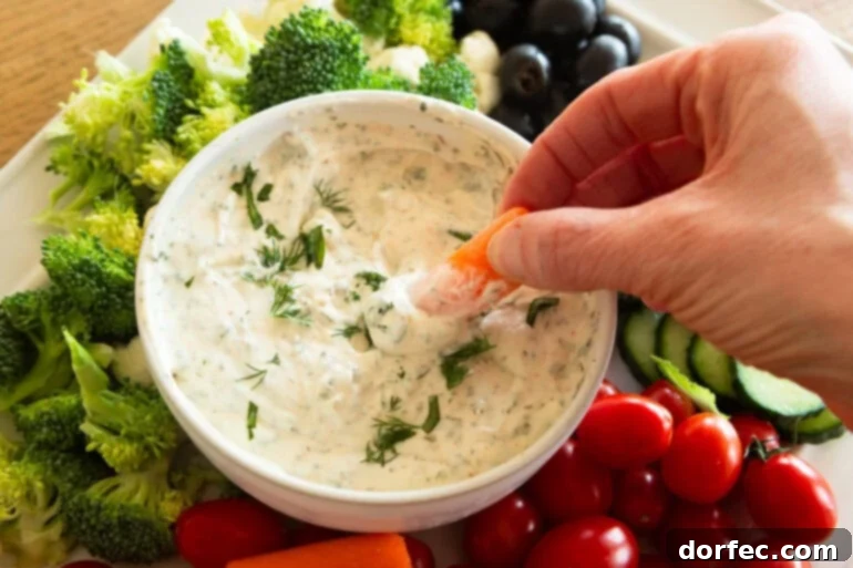 Creamy Herb and Garlic Vegetable Dip 4 Dipping a baby carrot into garlic herb veggie dip