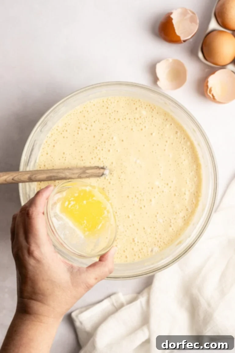 One Pan Strawberry Pancakes 11 Step-by-step image of spreading pancake batter onto a prepared sheet pan.