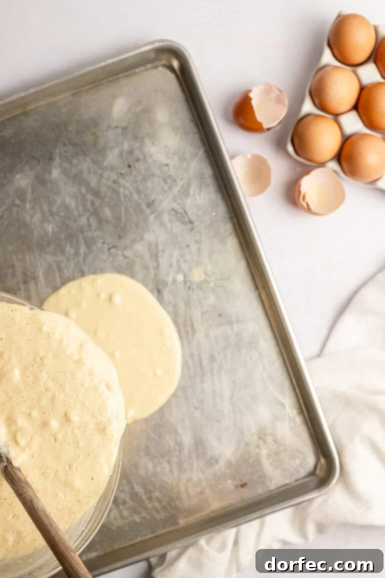 One Pan Strawberry Pancakes 12 Step-by-step image of sprinkling strawberry slices over sheet pan pancake batter before baking.