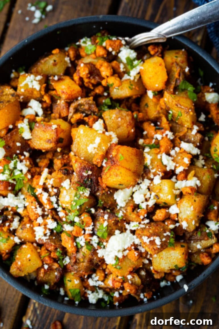 A vibrant photo of a dish of savory chorizo and golden potatoes, generously mixed with cotija cheese and fresh cilantro.
