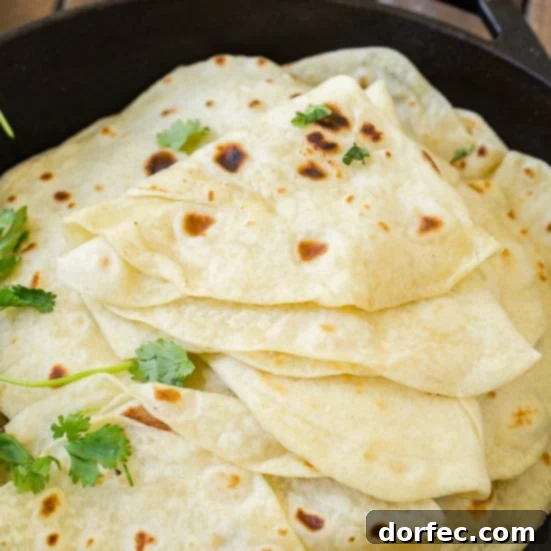 A stack of soft, warm homemade flour tortillas, perfect for any Mexican meal.