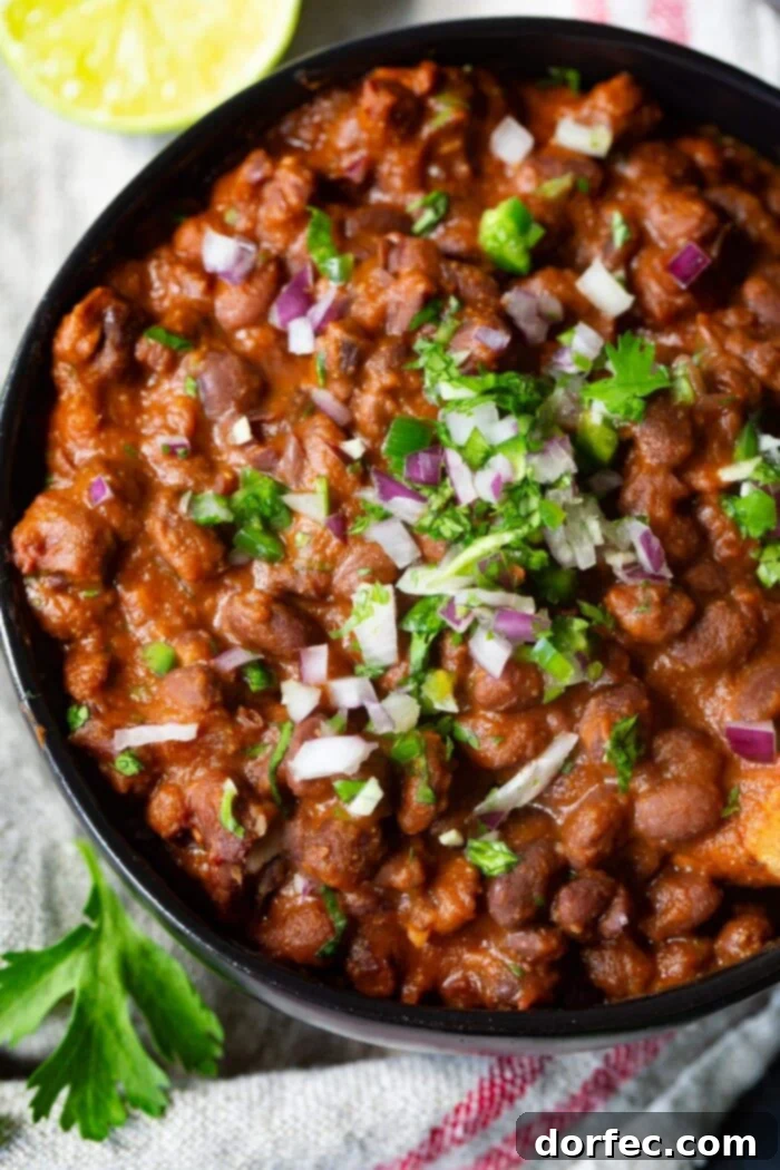 A delicious bowl of Mexican black beans, elegantly topped with finely diced red onion and freshly chopped cilantro.