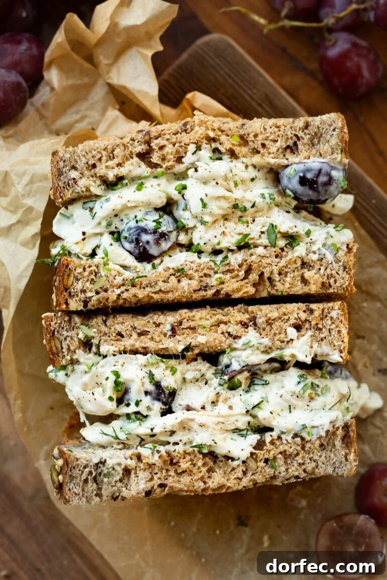 Close-up of shredded chicken salad layered between slices of wheat sandwich bread.