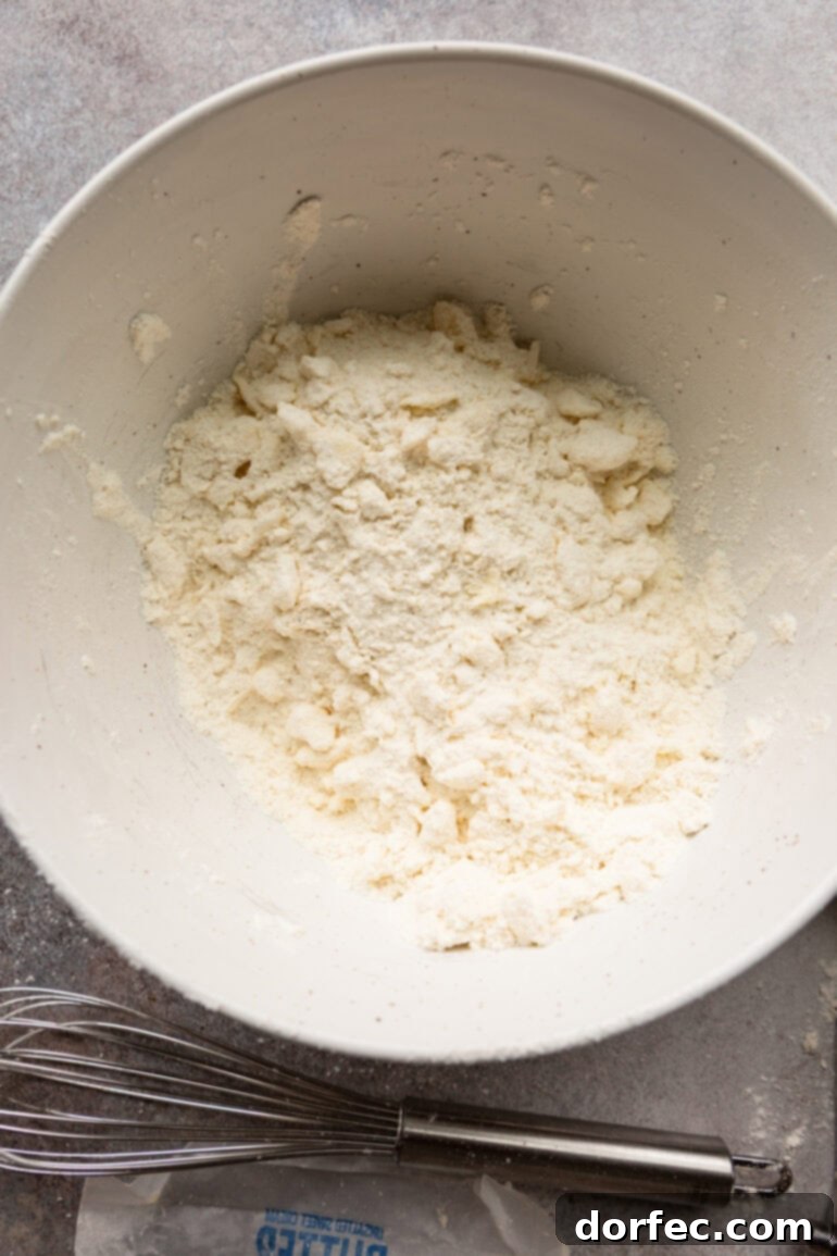 Step-by-step image showing butter being cut into flour for biscuits.