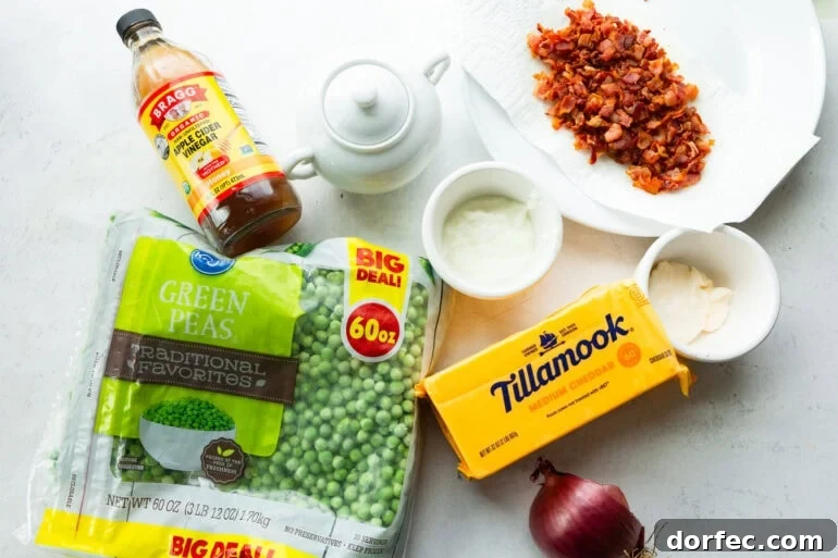all the ingredients for english pea salad including peas, cheddar cheese, bacon, red onion, etc