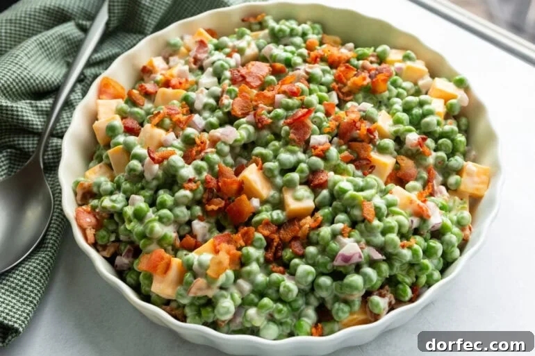 a large white serving bowl of creamy English pea salad
