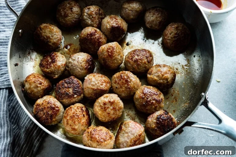 meatballs being browned in a large skillet