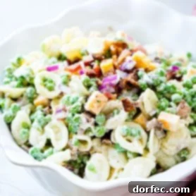 Crowd Pleasing Pasta Salads Made Easy for Potlucks 4 Southern-style English Pea Pasta Salad with cheese and bacon in a white serving bowl.