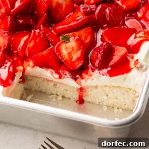a photo of a single layer white cake topped with cream cheese frosting and juicy red strawberries with some slices removed so you can see the cross section