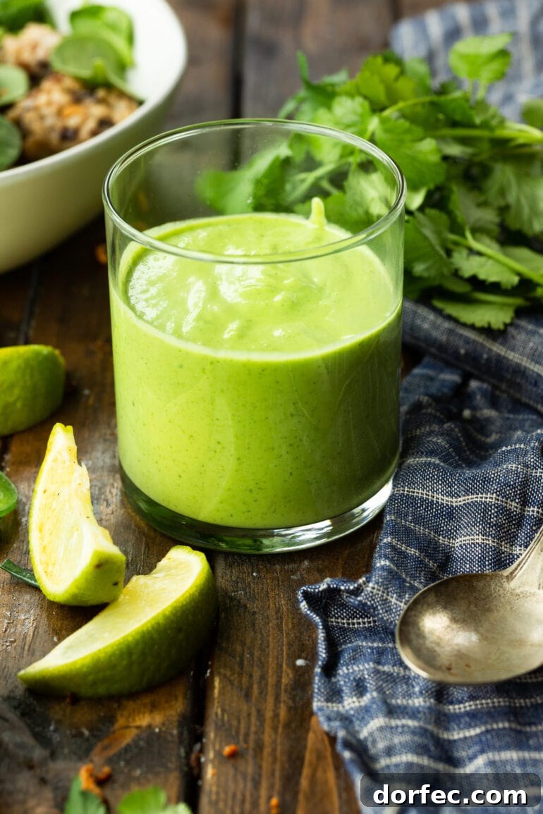 a photo of a glass cup full of avocado cilantro lime dressing.
