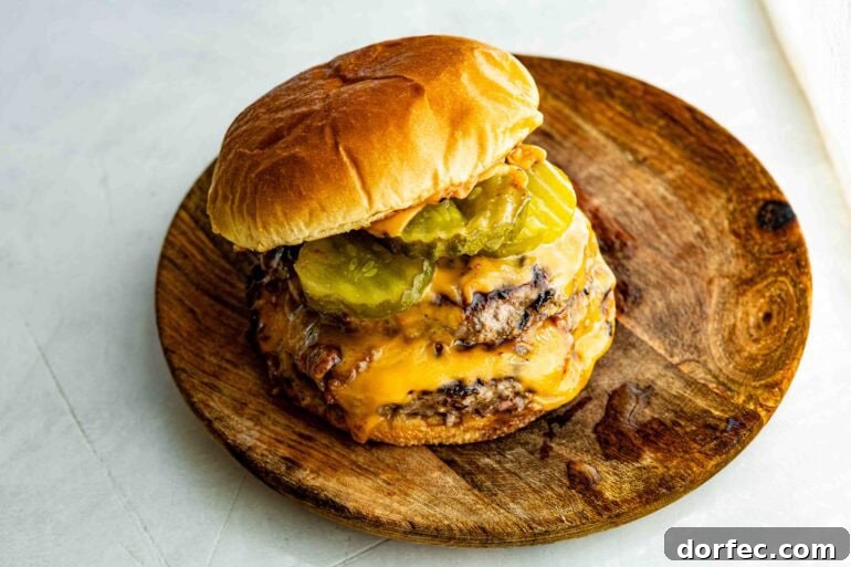 a juicy, double patty cheeseburger with melty cheese and dill pickle rounds on a toasted brioche bun