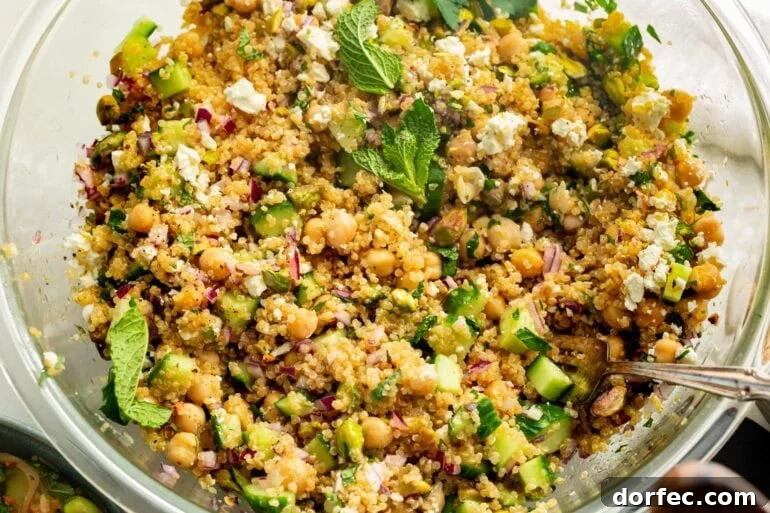 a large bowl of jennifer aniston salad topped with mint leaves and a lemon dressing