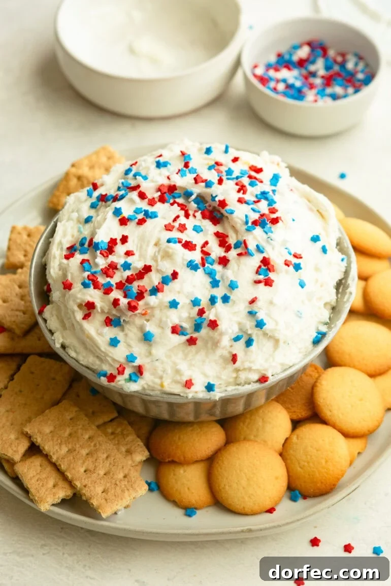Overhead of Funfetti Dip in a bowl topped with sprinkles, surrounded by Nilla wafers and graham crackers.
